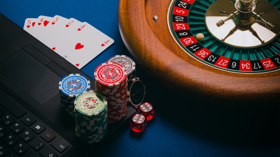 Roda roulette dan tumpukan chip warna-warni di meja kasino