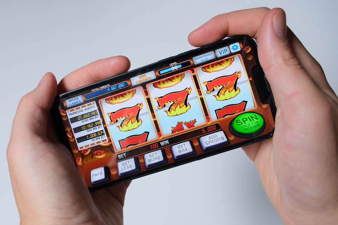 Tangan pengguna memegang ponsel untuk bermain game daring